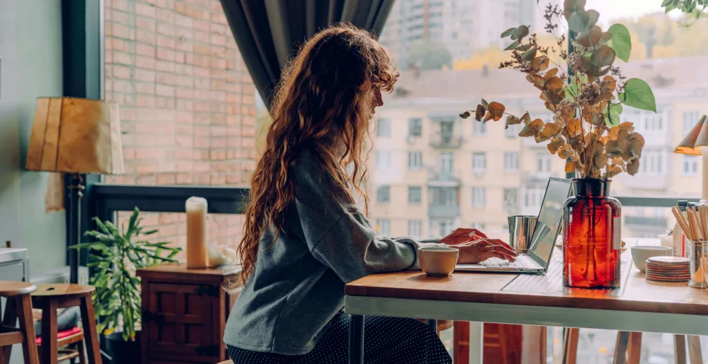 Young woman typing at a window 