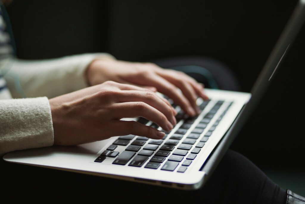 A woman's hand on a keyboard, participating in the 24-Hour Novel Challenge - Photo by Kaitlyn Baker on Unsplash