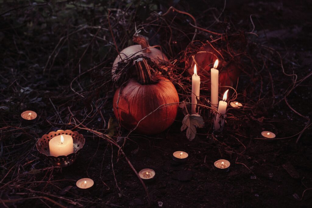 Pumpkins and candles on a dark background - Photo by freestocks on Unsplash